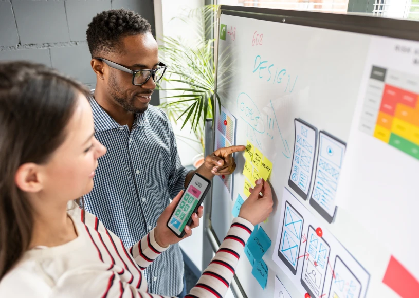 Designers collaborating on project at whiteboard